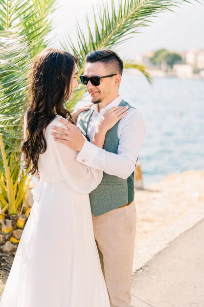 Bride and groom hug with their hands on each other shoulders