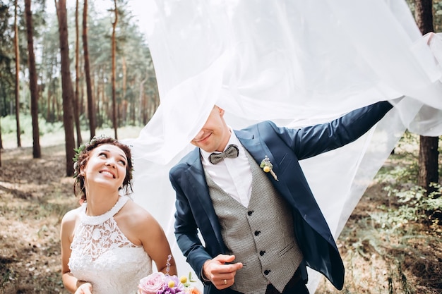 Bride and groom hugging, kissing outdoors on a wedding day, young couple, valentine's day