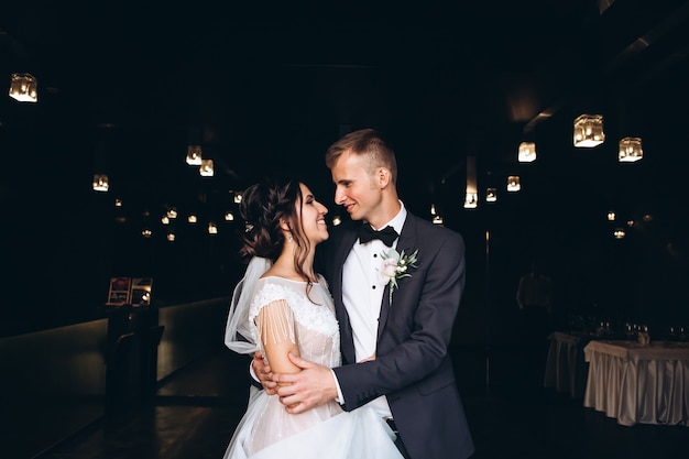 Bride and groom hugging, kissing outdoors on a wedding day, young couple, valentine's day