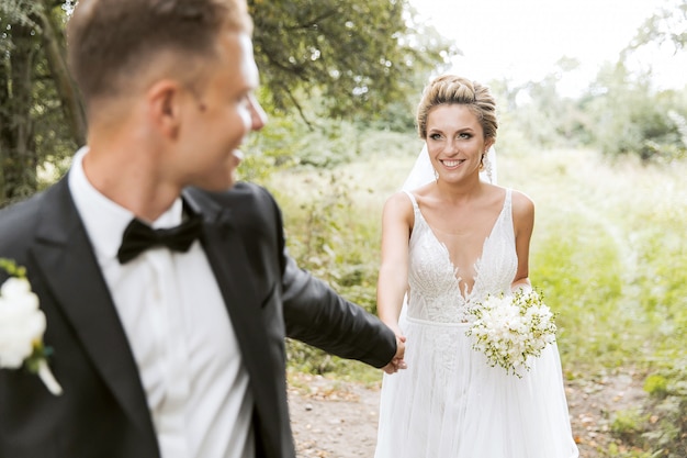 Bride and groom hugging in the old town street. Wedding couple in love. Luxury rhinestone dress. Hot summer days.