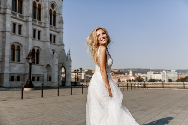 Bride and groom hugging in the old town street. Wedding couple in love. Luxury rhinestone dress.