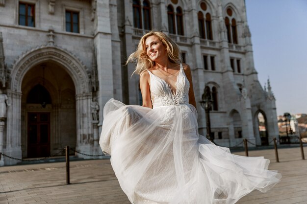 Bride and groom hugging in the old town street. Wedding couple in love. Luxury rhinestone dress.