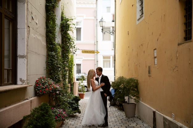 Жених и невеста обнимаются на улице Старого города. Свадебная пара в любви. Роскошное платье со стразами.