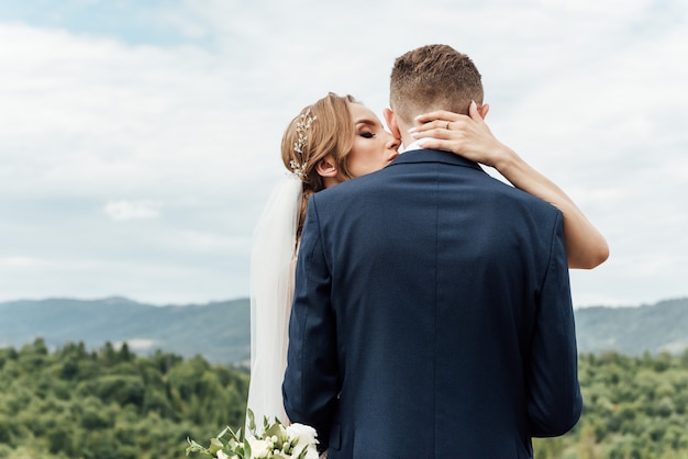Жених и невеста обнимаются на свадьбе на природе