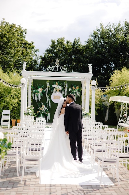 a bride and groom kiss on the aisle