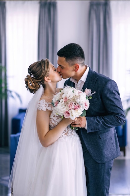 The bride and groom kiss in a restaurant at the wedding Happy newlyweds after the ceremony