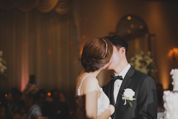 A bride and groom kiss at a wedding reception