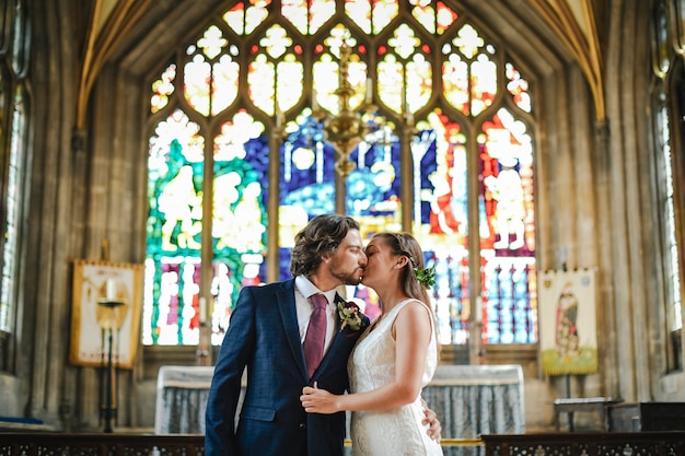 Bride and groom kissing at the altar