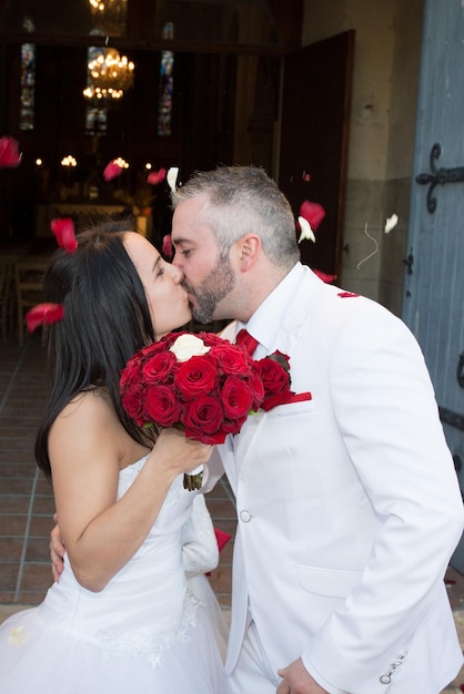 Bride and groom kissing in front of church