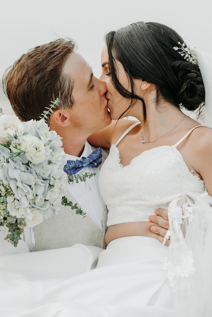 The bride and groom kissing Newlyweds with a wedding bouquet