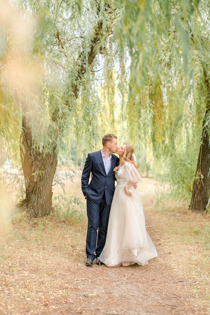 Bride and groom kissing in the park