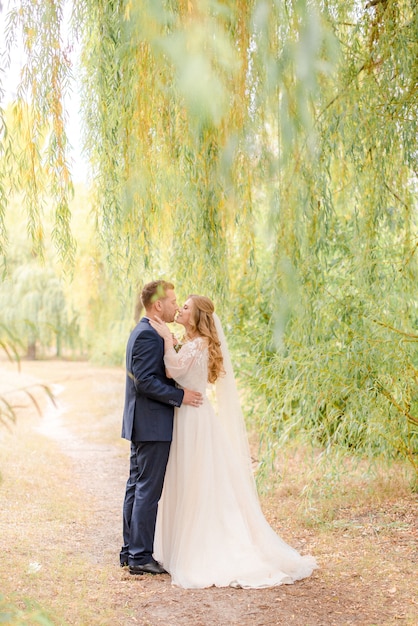 Bride and groom kissing under the tree