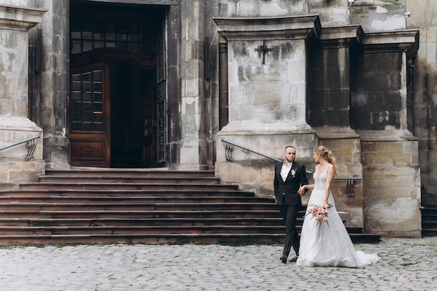 Bride and groom look awesome posing near old church