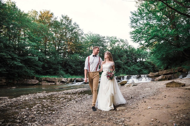 Bride and groom near mountain river