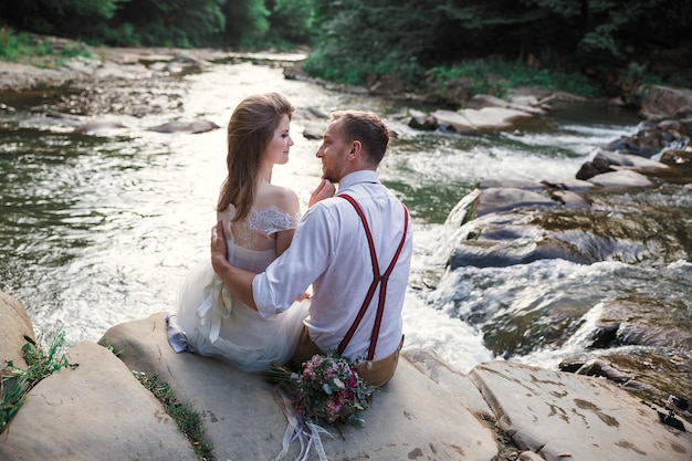 Bride and groom near mountain river