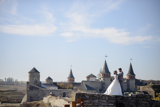 Bride and groom near an old castle