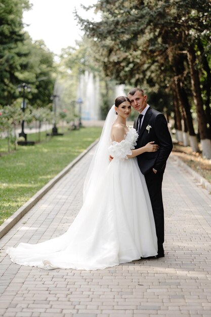 Photo a bride and groom pose for a photo in a park