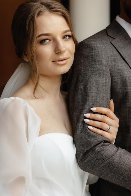 A bride and groom pose for a photo.