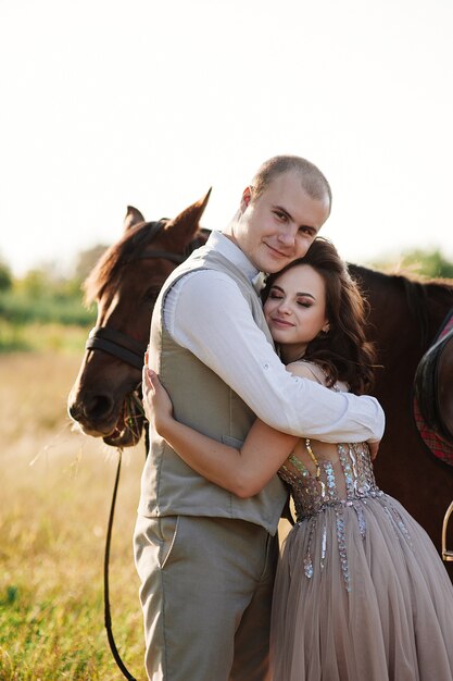 Photo bride and groom posing across the field