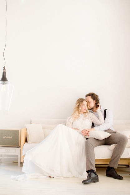 Bride and groom posing in a bright room