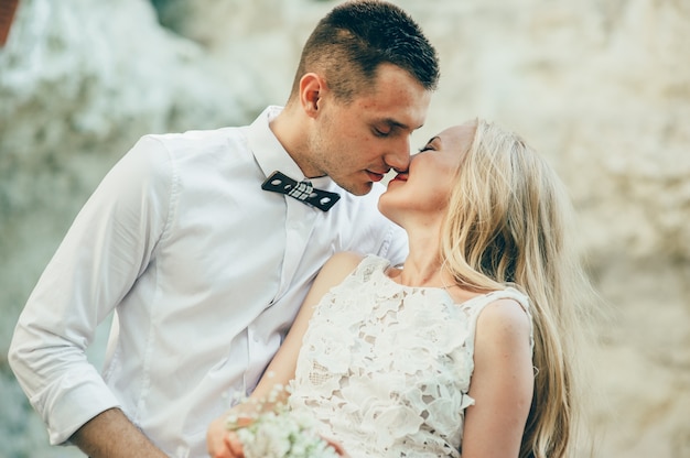 bride and groom posing on the mountain on a sunny day