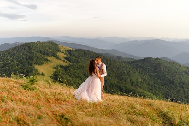 Bride and groom posing in the mountains