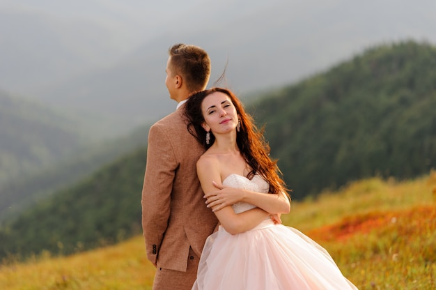 Bride and groom posing in the mountains