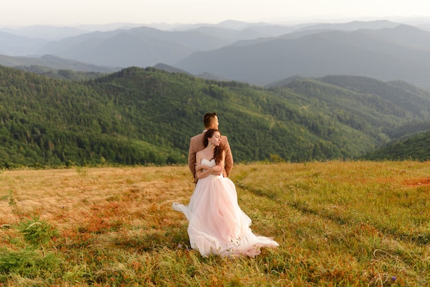 Жених и невеста позирует в горах