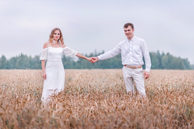 Sposa e sposo in posa su un campo di grano