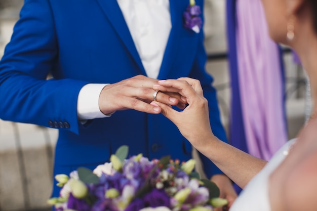 Bride and groom put on the finger a wedding ring