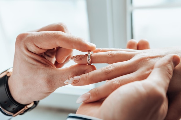 Bride and groom puts on wedding rings