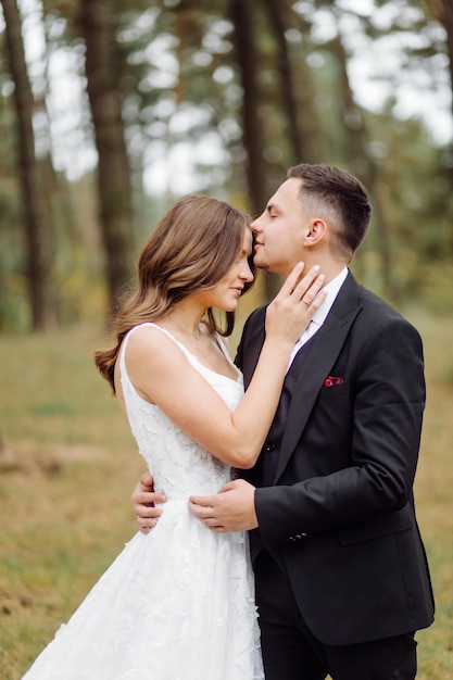 Gli sposi corrono attraverso una foresta servizio fotografico di matrimonio