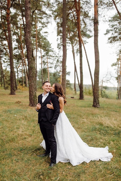 Foto gli sposi corrono attraverso una foresta servizio fotografico di matrimonio