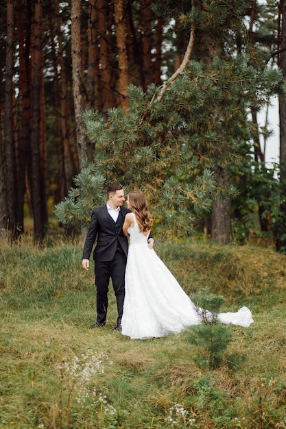 Gli sposi corrono attraverso una foresta servizio fotografico di matrimonio