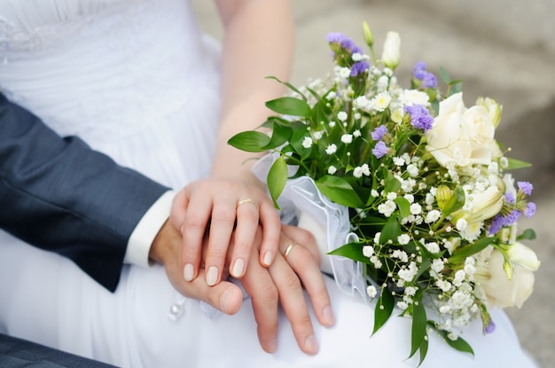 Mani dello sposo e della sposa con fedi nuziali