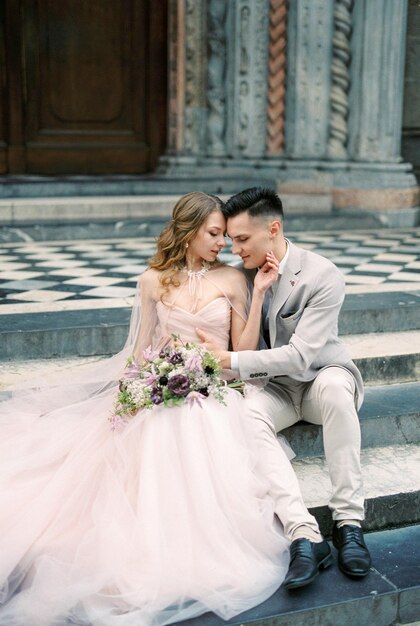 Bride and groom sit on the steps Bergamo Italy