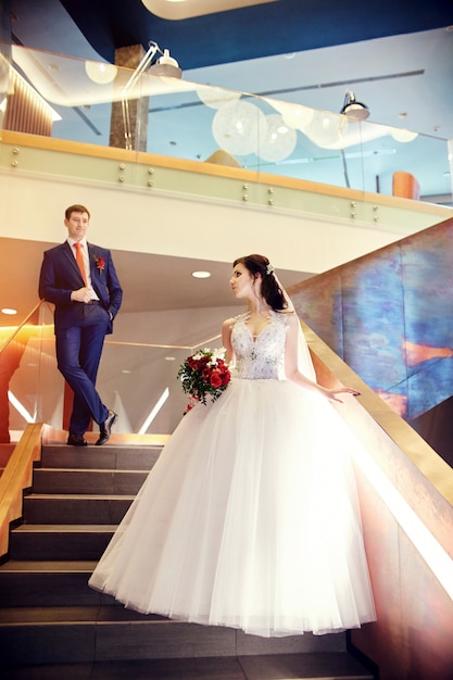 Bride and groom standing on the stairs wedding