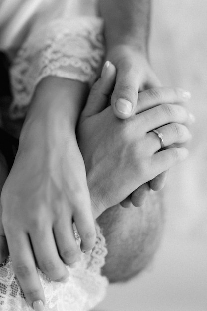 The bride and groom tenderly hold hands between them love and relationships