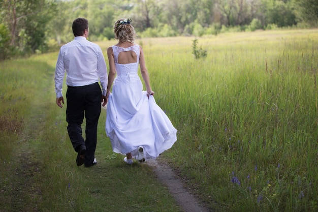 Bride and groom walking along the forest road