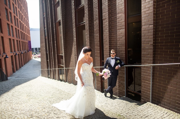 Bride and groom walking in the city, wedding day, marriage . Bride and groom in urban . Young couple in wedding day.