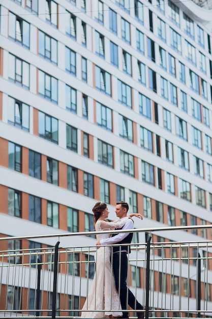 Sposa e sposo che camminano nella città, giorno delle nozze, concetto di matrimonio. sposa e sposo nel fondo urbano. giovane coppia andando su una scala nel giorno del matrimonio.