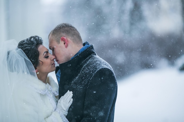 雪の中でヨーロッパの街を歩く新郎新婦