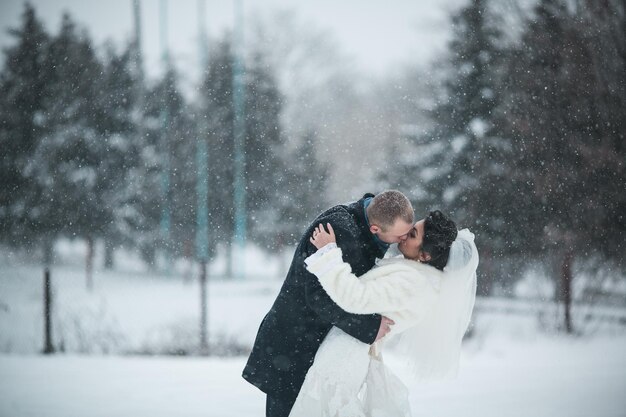 Bride and groom walking on the European city in the snow