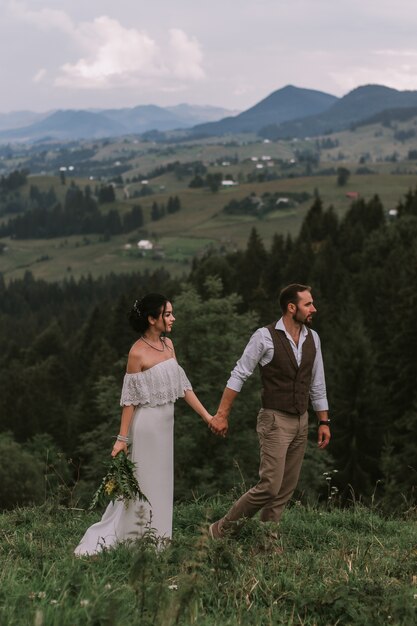 Bride and groom walking in mountains