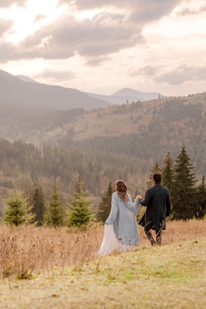 Bride and groom walking in mountains