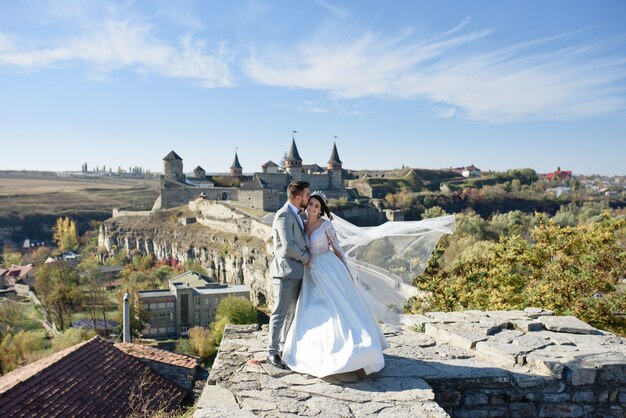 Bride and groom walking near the old castle