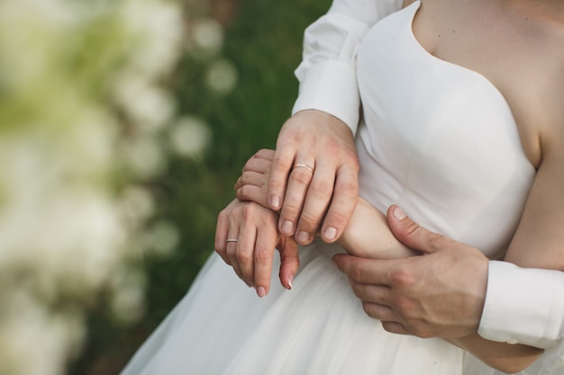 Sposa e sposo che camminano insieme tenendo le mani