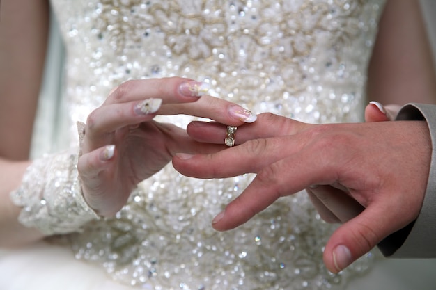 Bride and groom wear wedding rings to each other