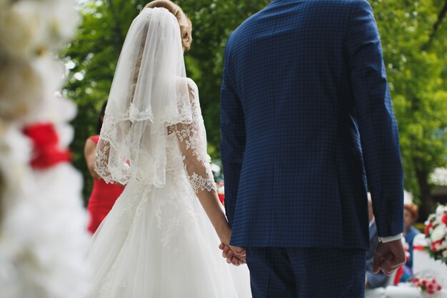 Bride and groom at a wedding ceremony holding hands