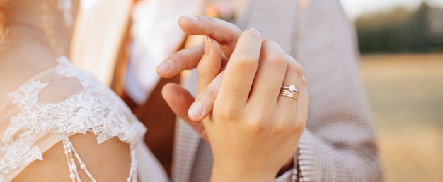 Gli sposi il giorno del matrimonio si abbracciano e mostrano amore al tramonto